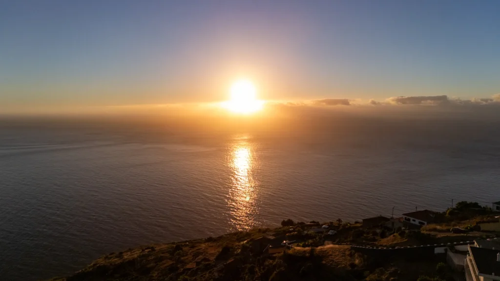 Aerial sunset view over the Atlantic from above Villa Espigão, with the coastal hillside below