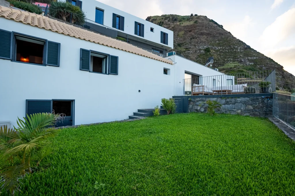 O exterior da Villa Escaleiras, uma casa branca com telhado de telha tradicional e janelas com portadas