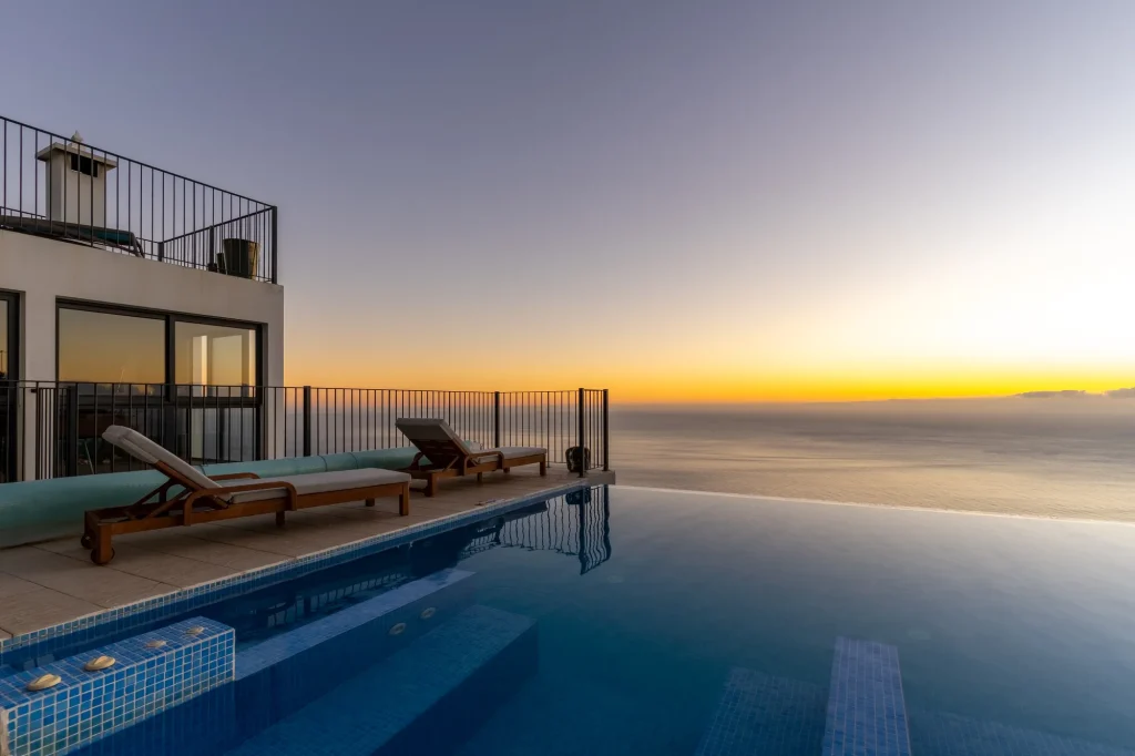 Villa Espigão's infinity pool at sunset, above the Atlantic