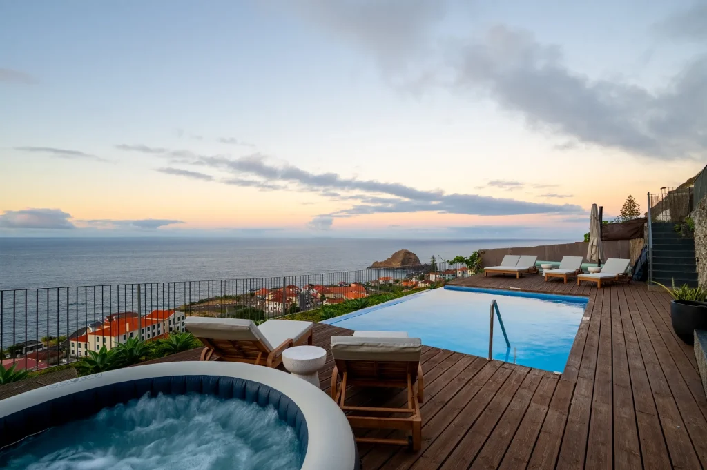 Villa Escaleiras' infinity pool and hot tub terrace at dusk, overlooking Porto Moniz