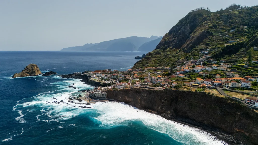 Aerial view of Porto Moniz on its headland, the islet and the Atlantic surf below the terraced cliffs, near Villa Domaterra II